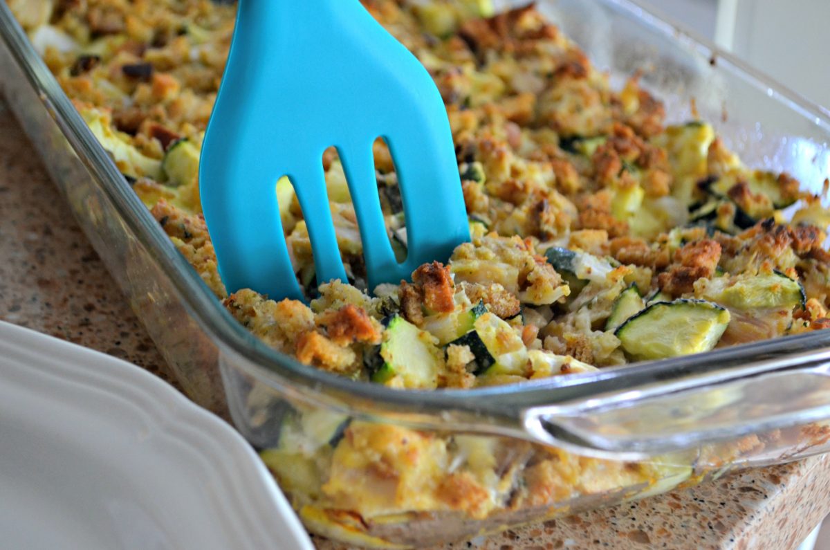 using a spatula to dish up chicken zucchini casserole