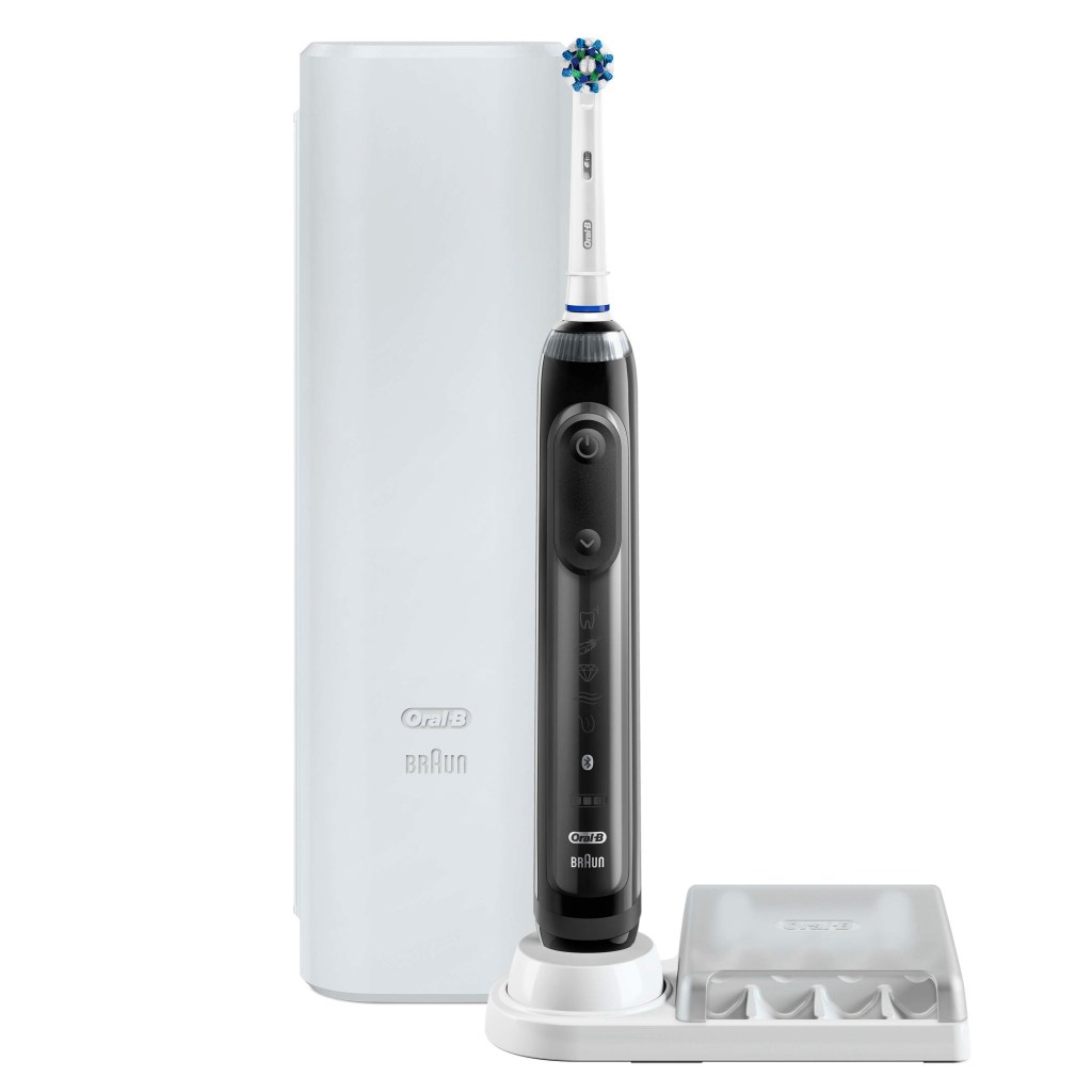 sleek black toothbrush next to charging dock and carrying pod