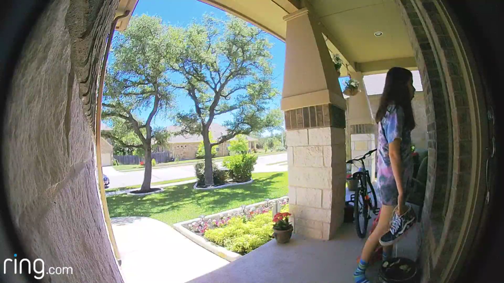 Girl standing outside on a porch ring doorbell