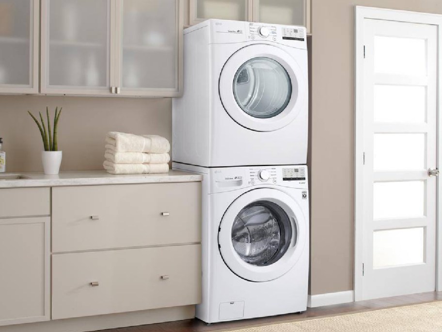 stacked front loader washer and dryer in white in laundry room