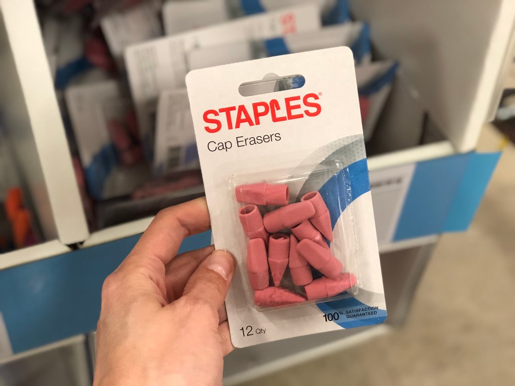 staples cap erasers in hand