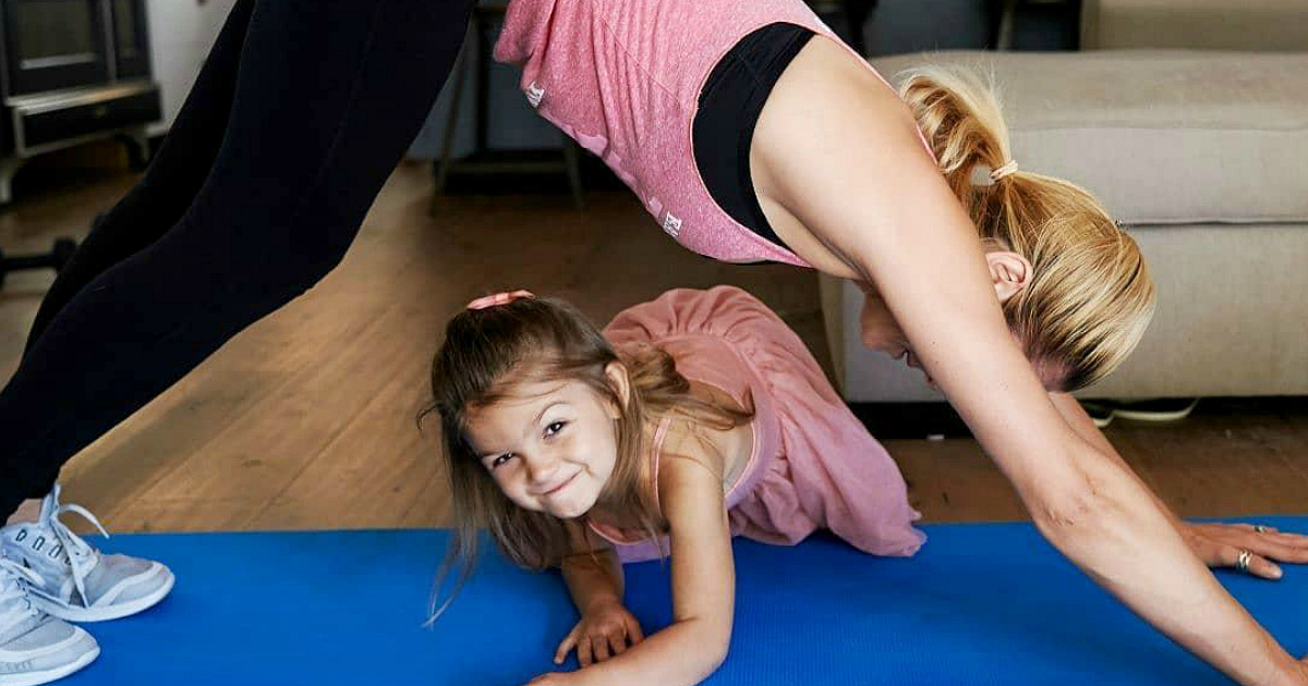 home workout session with daughter climbing on the mat