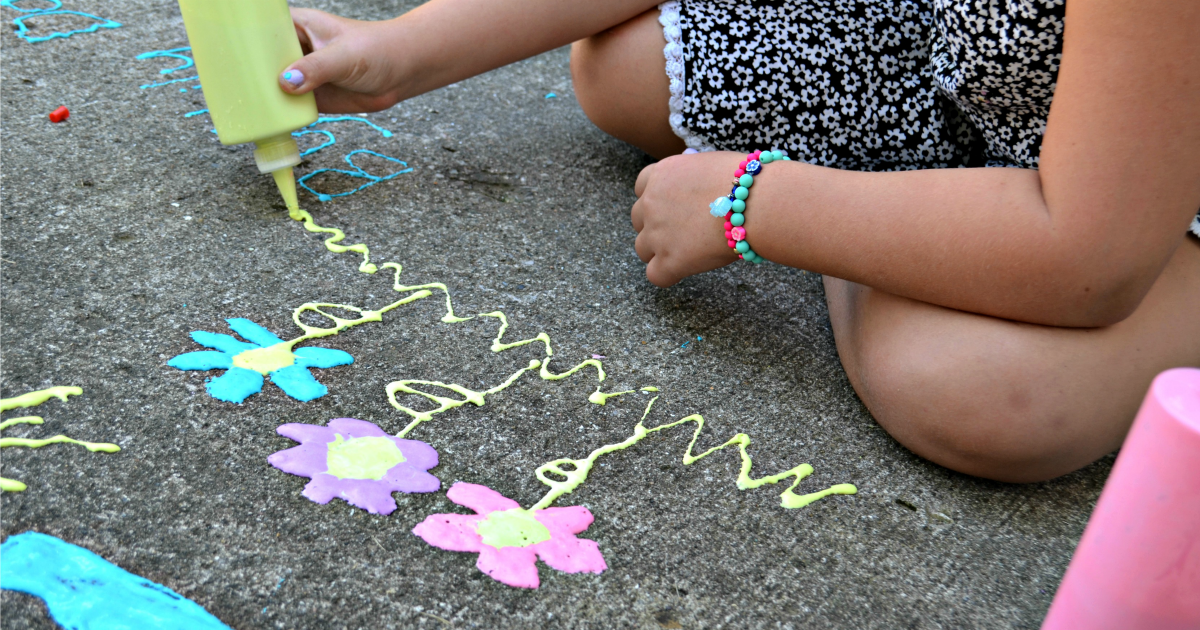 3-Ingredient DIY Puffy Sidewalk Paint - a young girl drawing with the paint