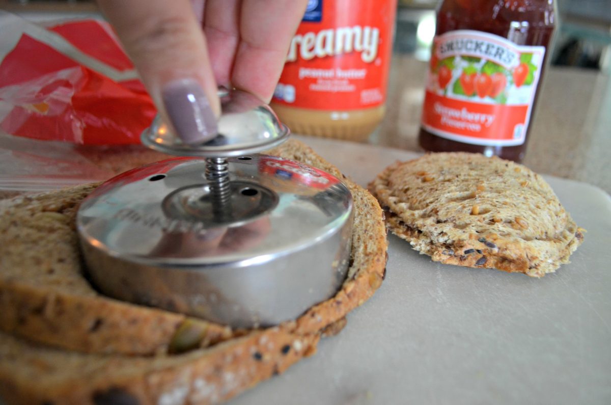 Hand pressing DIY Uncrustable maker into bread