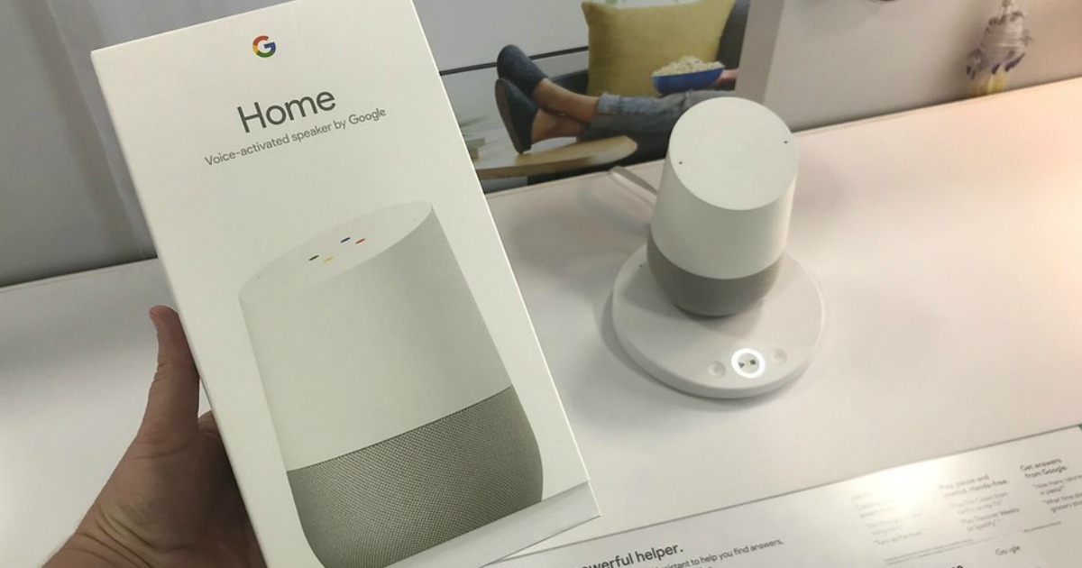 hand holding google home box in front of google home speaker on display in store