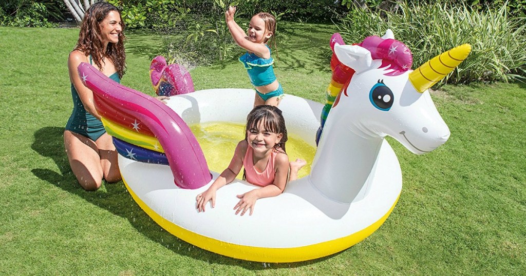 mom and 2 girls playing in unicorn shaped kiddie pool