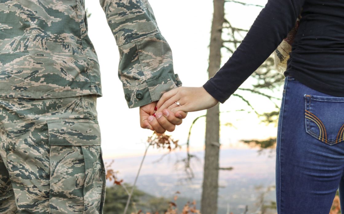 military service member holding hands with a woman