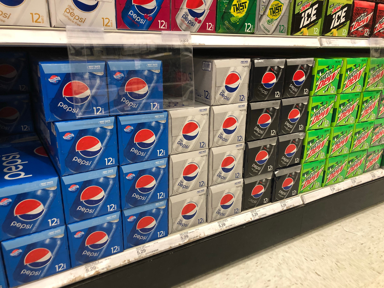 pepsi, diet pepsi and mountain dew stacked on shelves in store