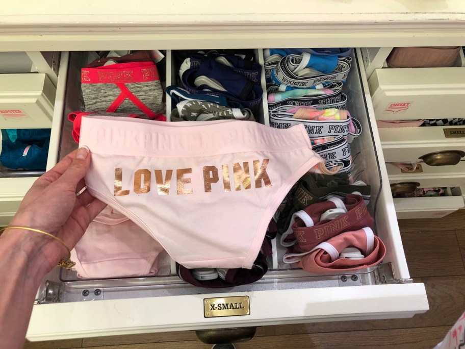 hand holding pink panty in store
