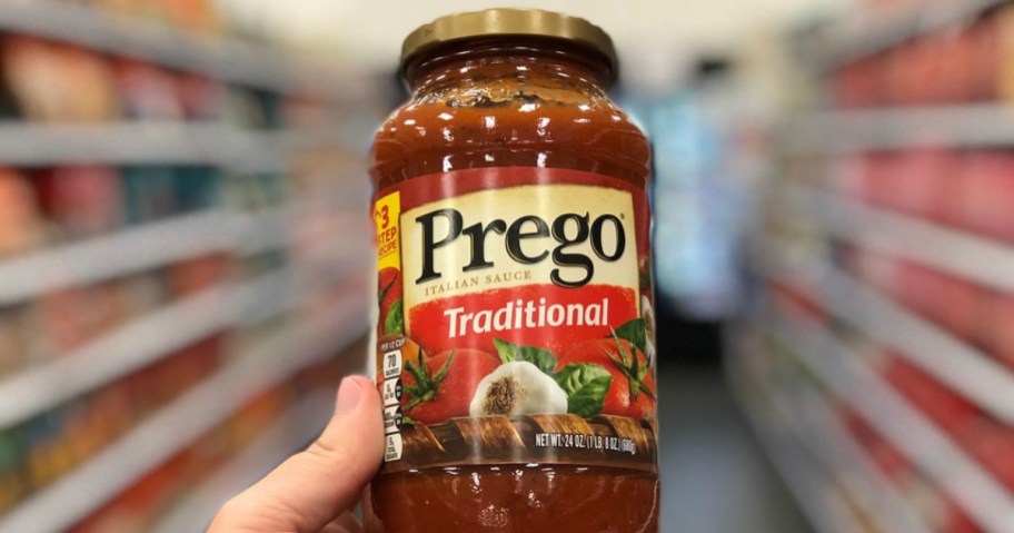 hand holding a jar of prego pasta sauce
