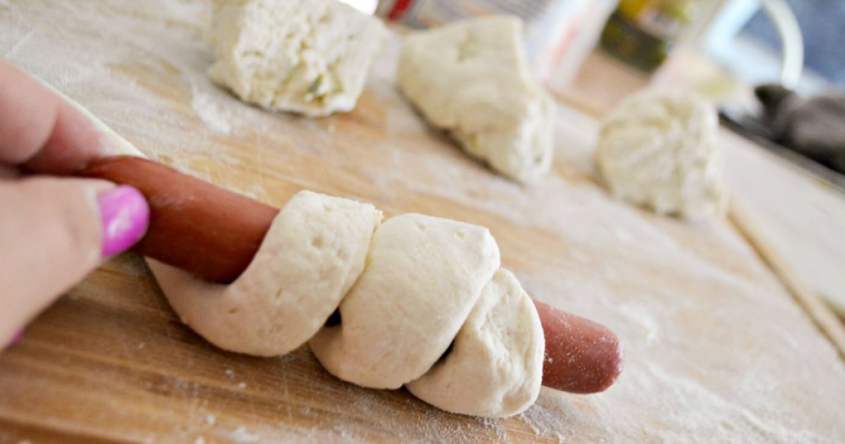 wrapping a hot dog with dough