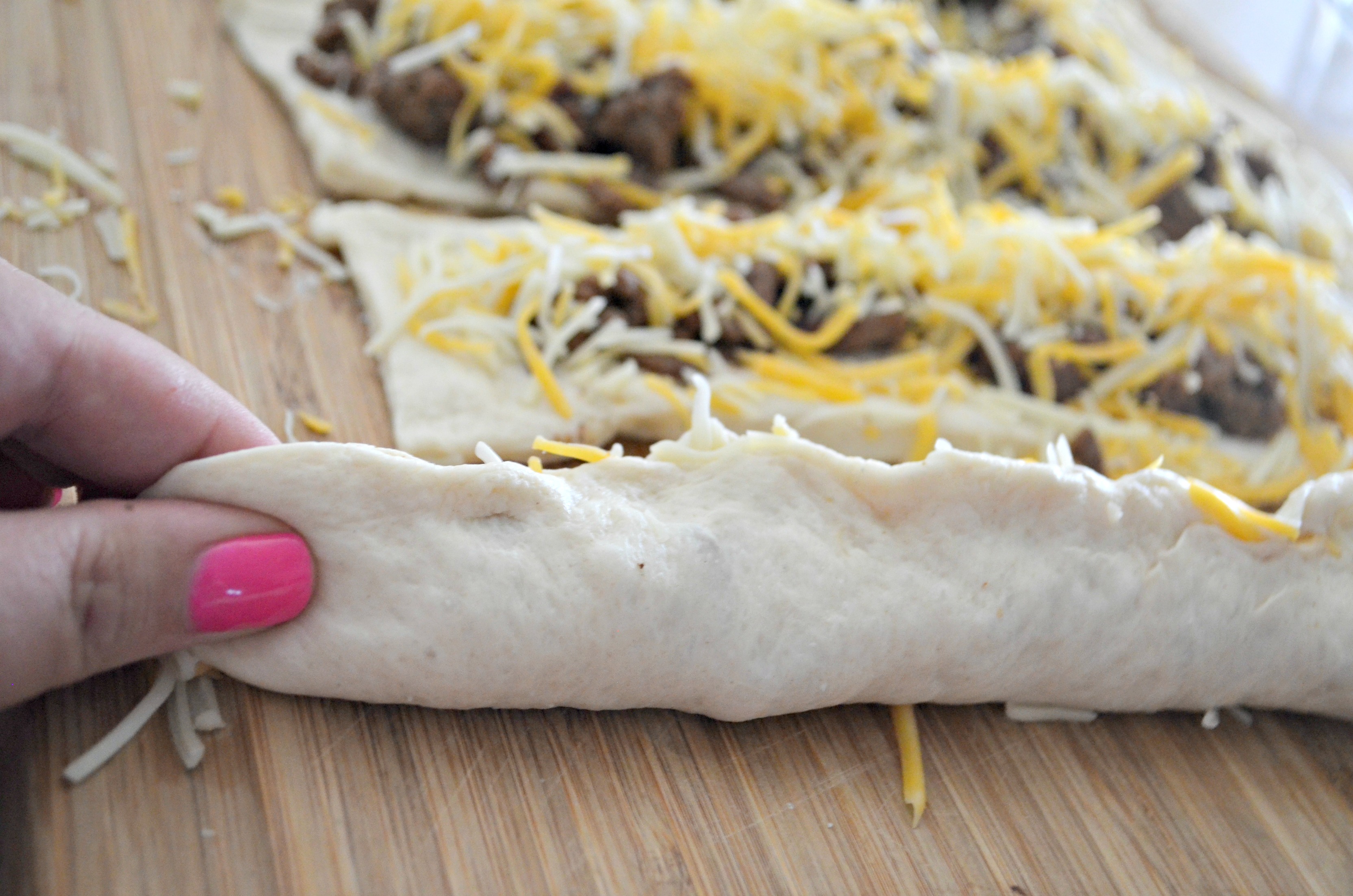 Easy 3 Ingredient Cheesy Taco Stuffed Breadsticks - pinching the dough together