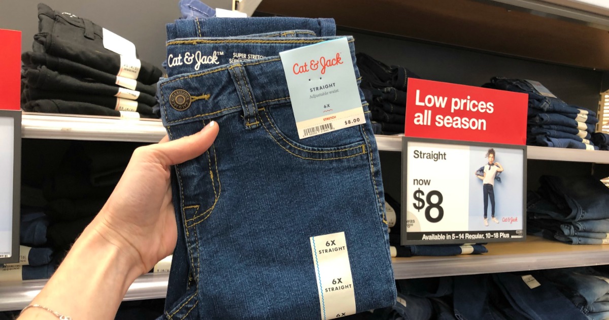 Hand holding up pair of kids jeans at Target
