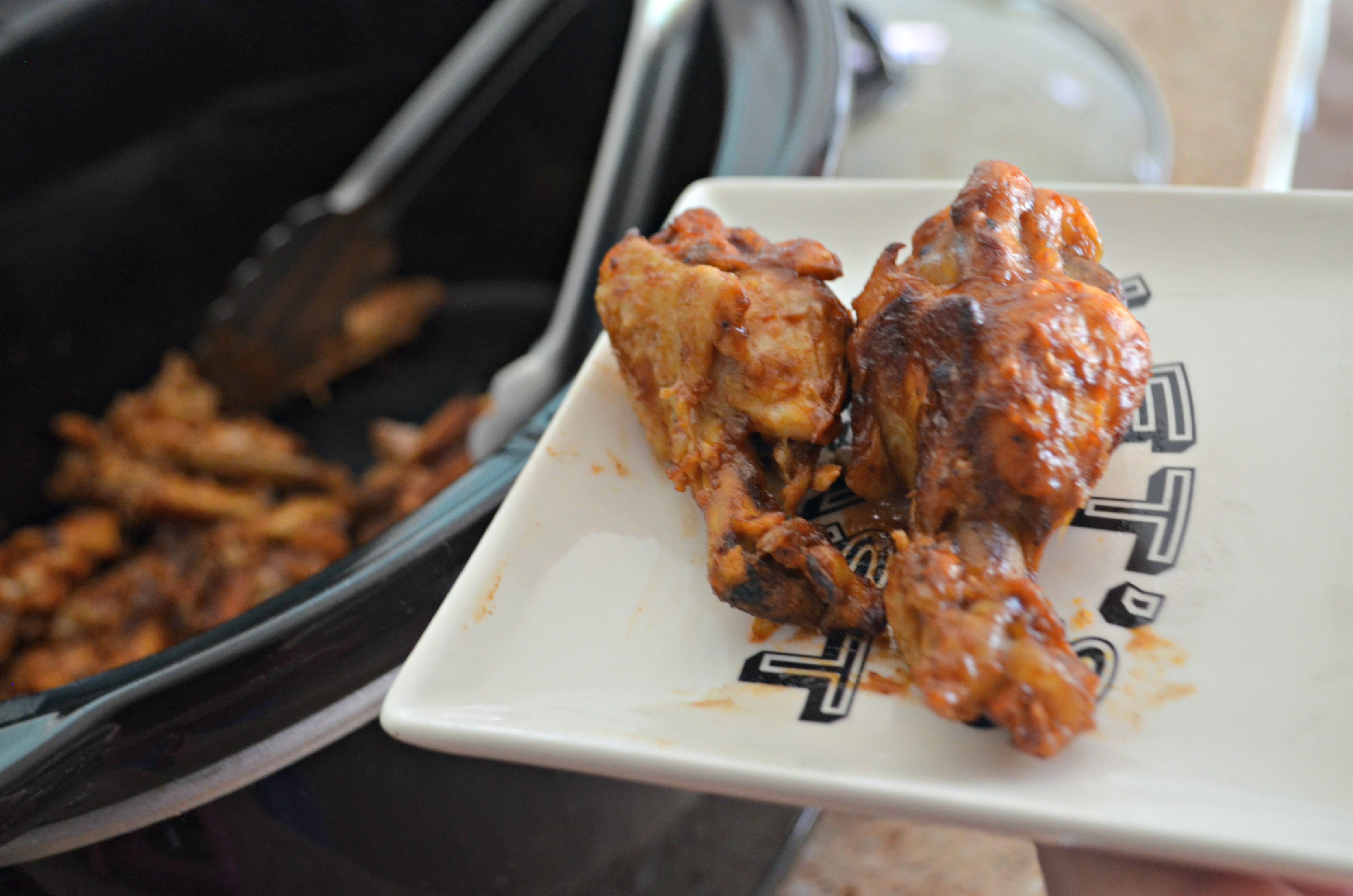easy slow cooker buffalo bbq chicken wings - wings on a plate