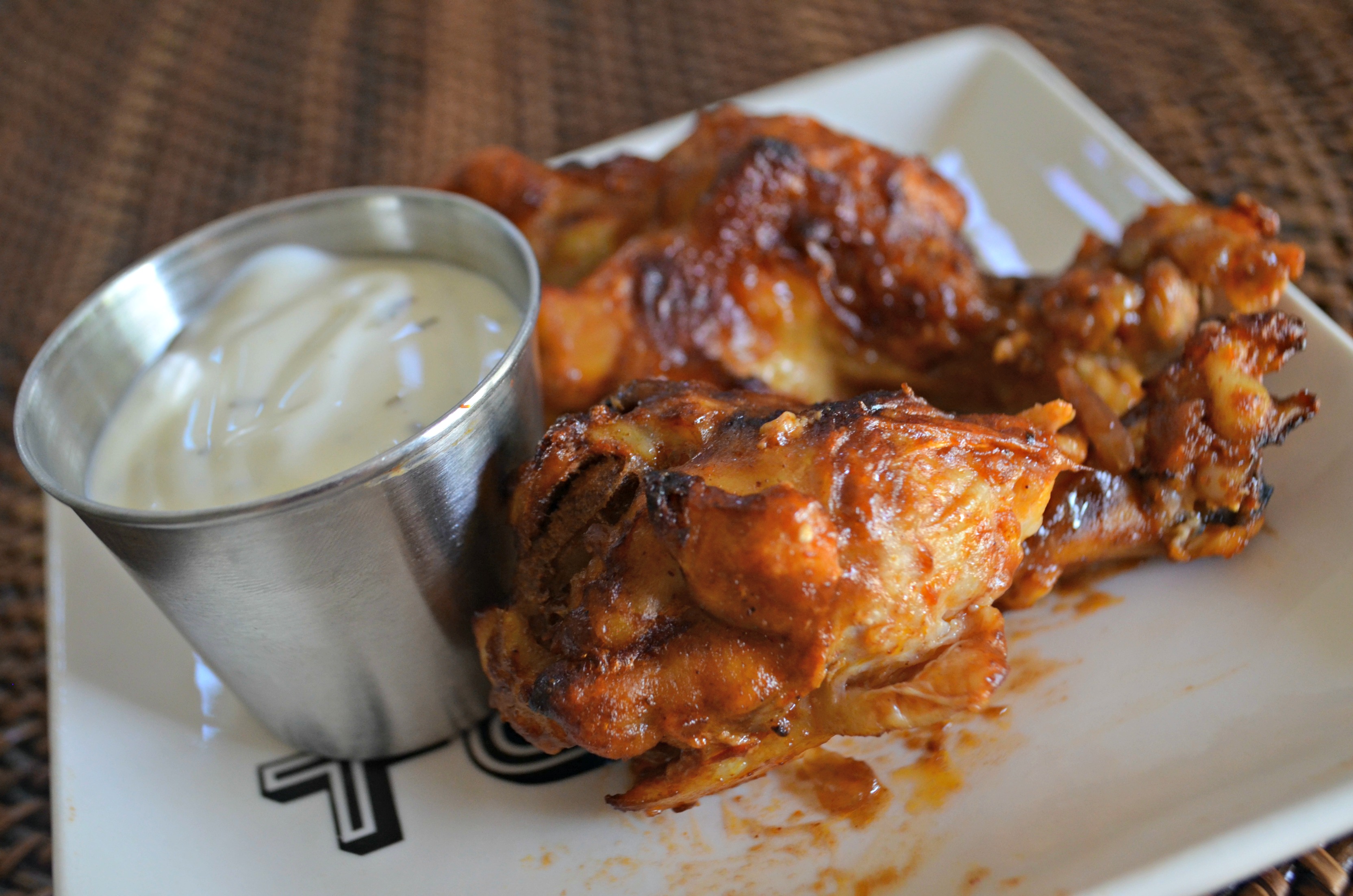 easy slow cooker buffalo bbq chicken wings - Wings on a plate with dipping sauce
