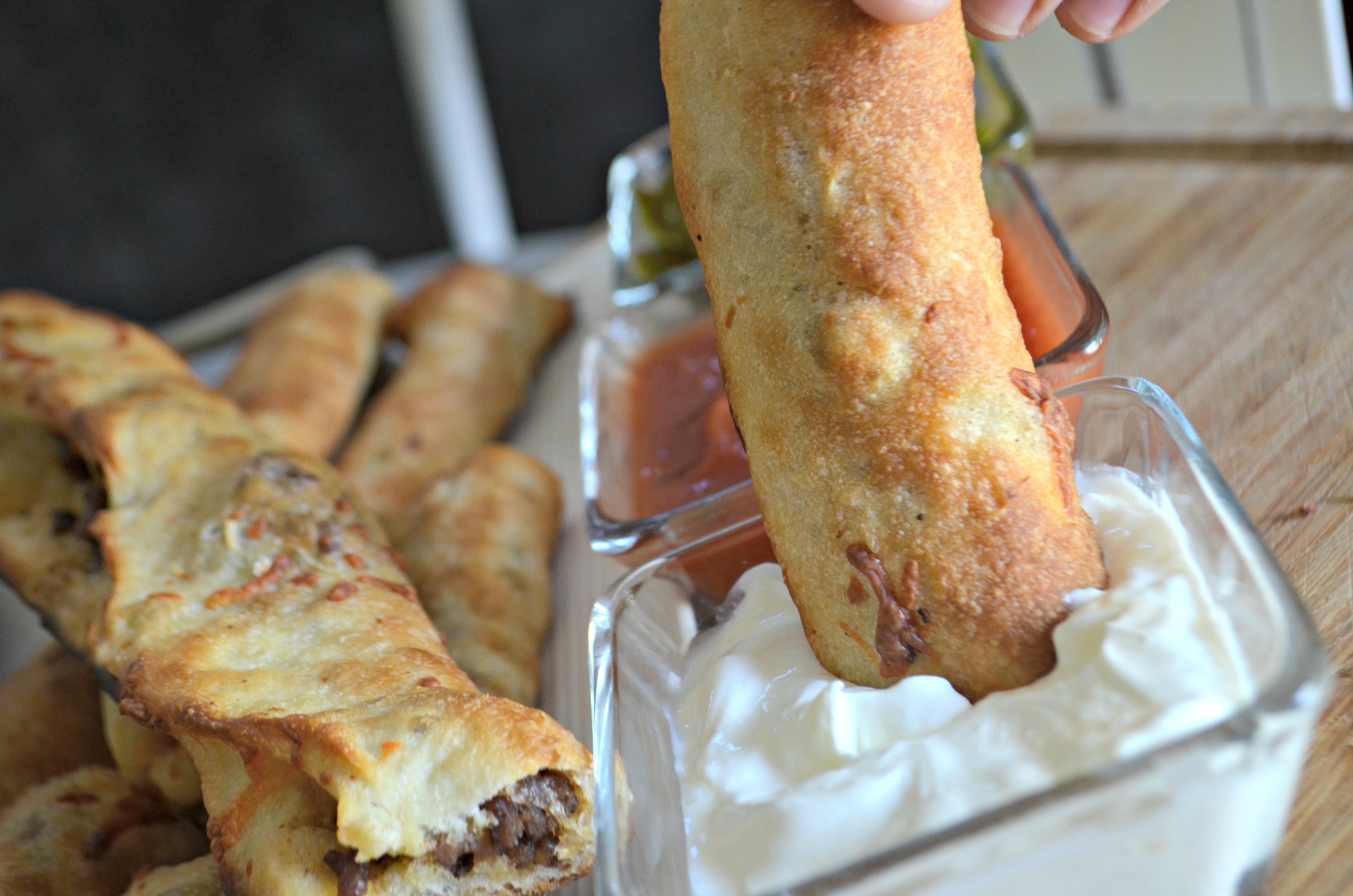 Easy 3 Ingredient Cheesy Taco Stuffed Breadsticks - dipping in sour cream