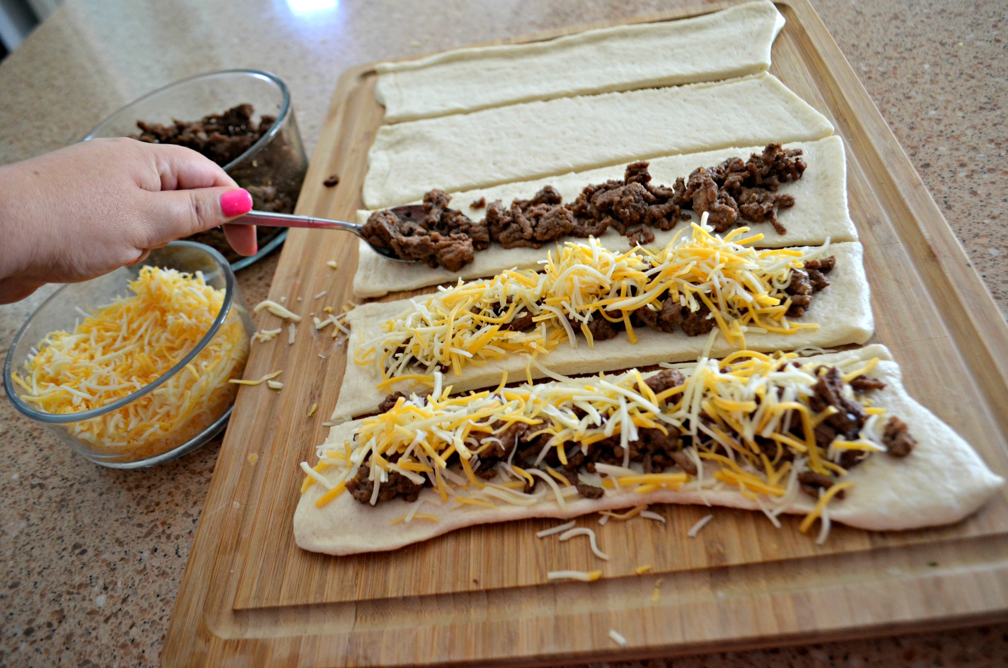 Easy 3 Ingredient Cheesy Taco Stuffed Breadsticks - assembling on a cutting board