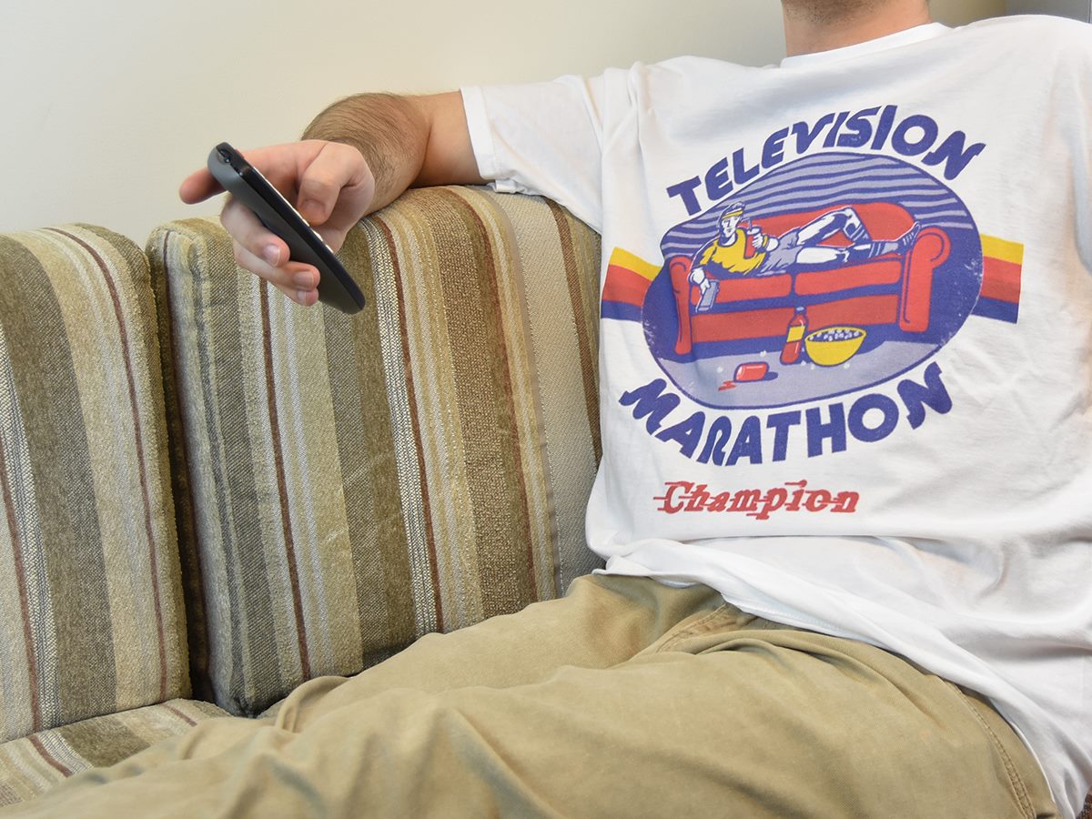 Student with a remote control and a "television marathon champion" tee