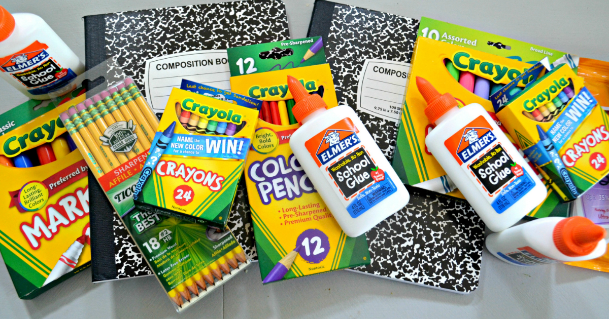 School supplies in a pile, including glue, pencils, composition notebooks, and crayons