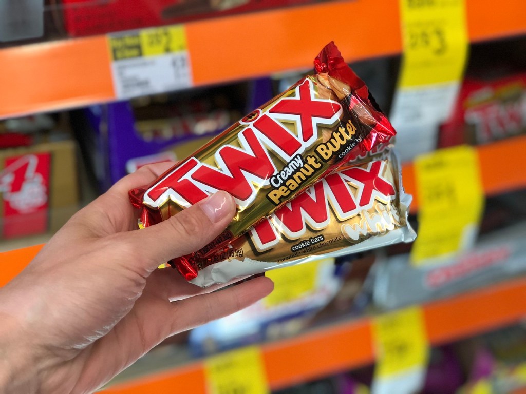 hand holding up a couple of twix candy bars