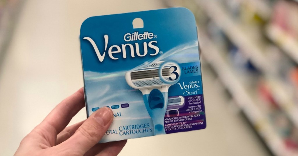 Hand Holding Gillette Venus Refill Blades in store aisle