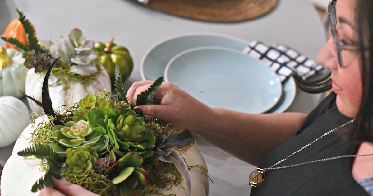 style your fall table with this DIY succulent centerpiece idea - here, Lina styling the pumpkin