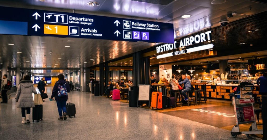 airport stores and hallway with various lights and signs for departures