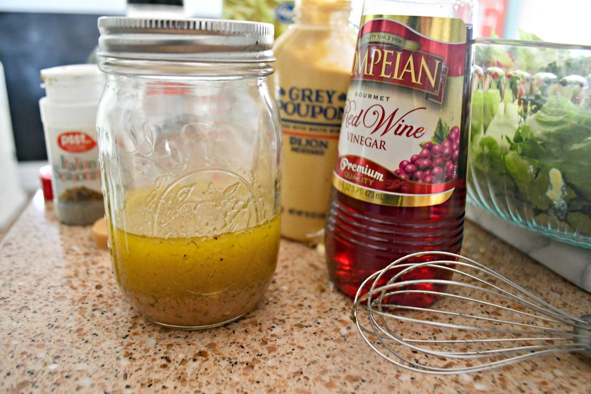 salad dressing in jar with vinegar and whisk 