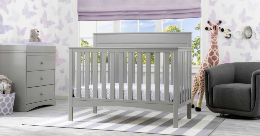 grey crib in front of window 