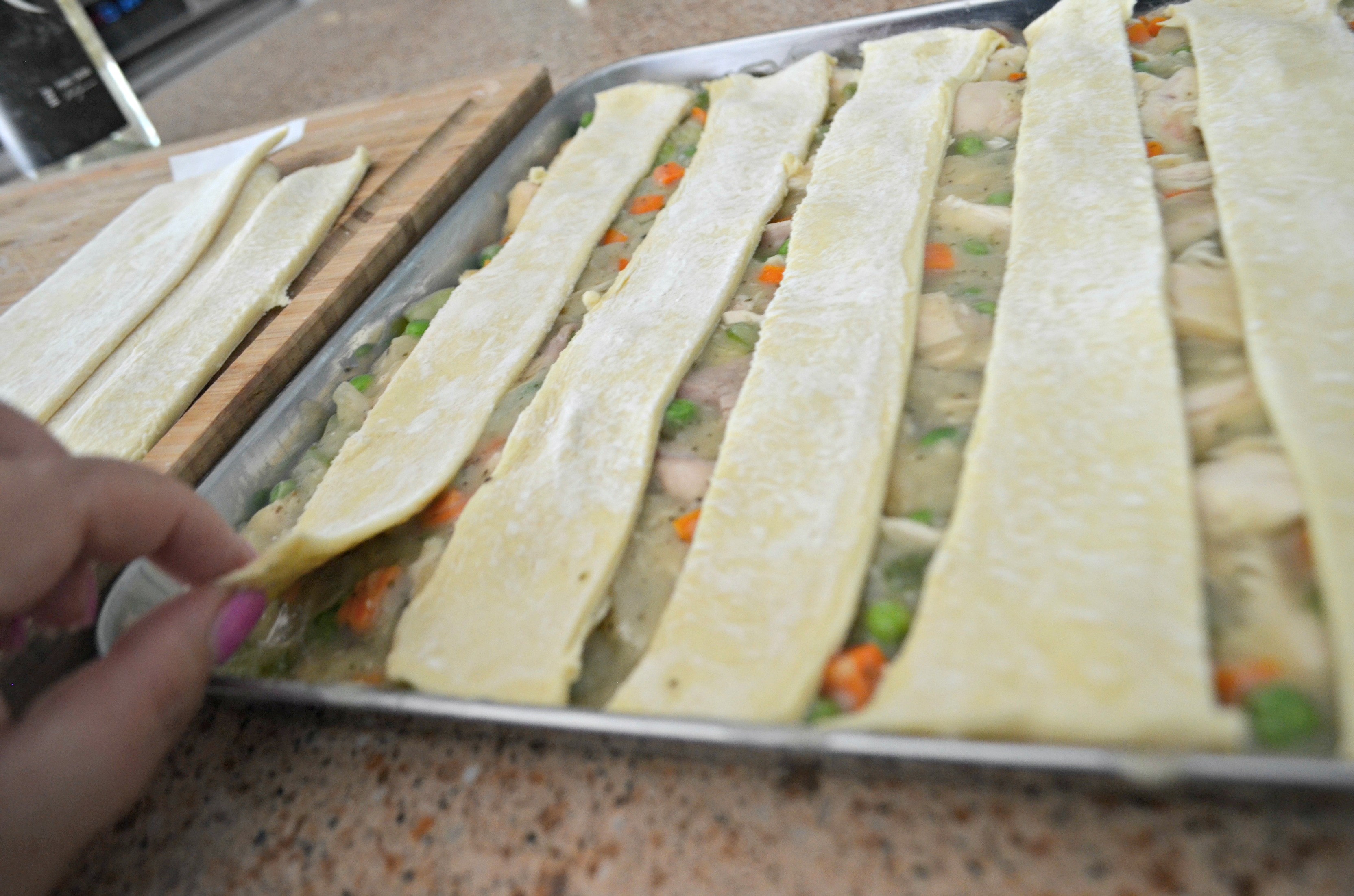 Sheet Pan Chicken Pot Pie -layering dough on top of the mixture in the pan