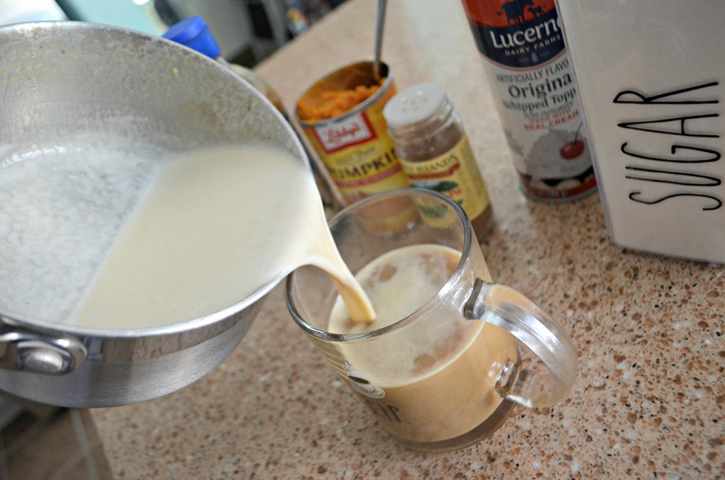 pouring in pumpkin spice latte into mug