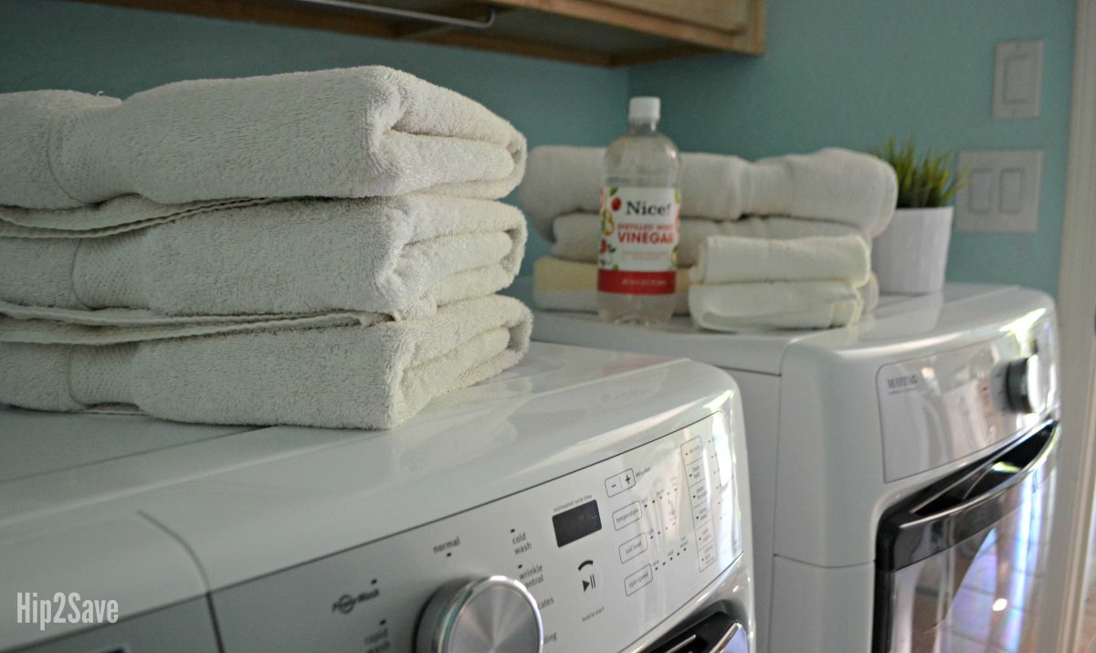 laundry room towels stacked next to a bottle of white vinegar