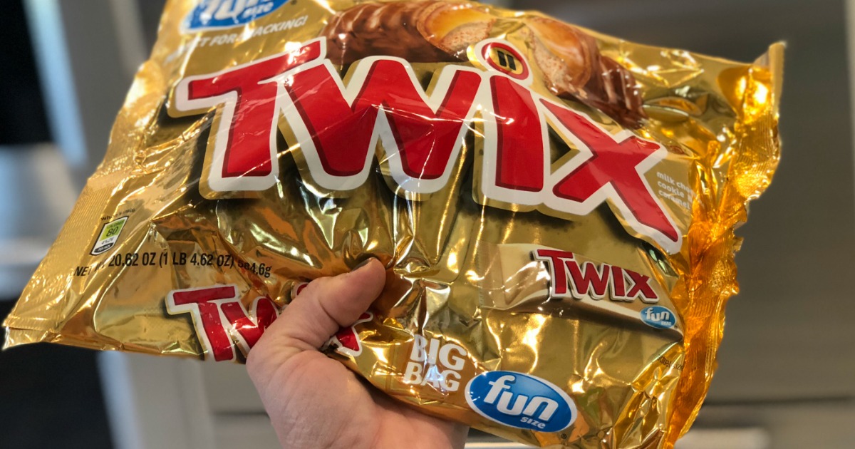 A person holding a bag of Twix candy