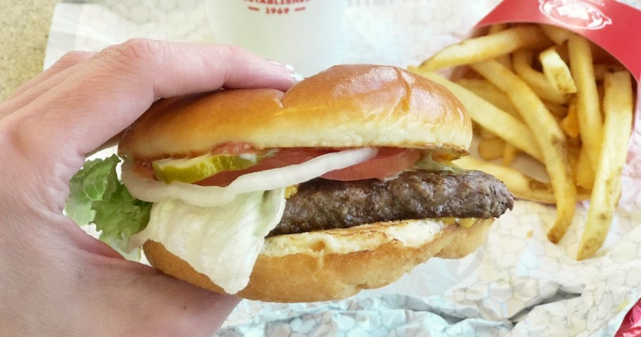 hand holding a wendy's cheeseburger