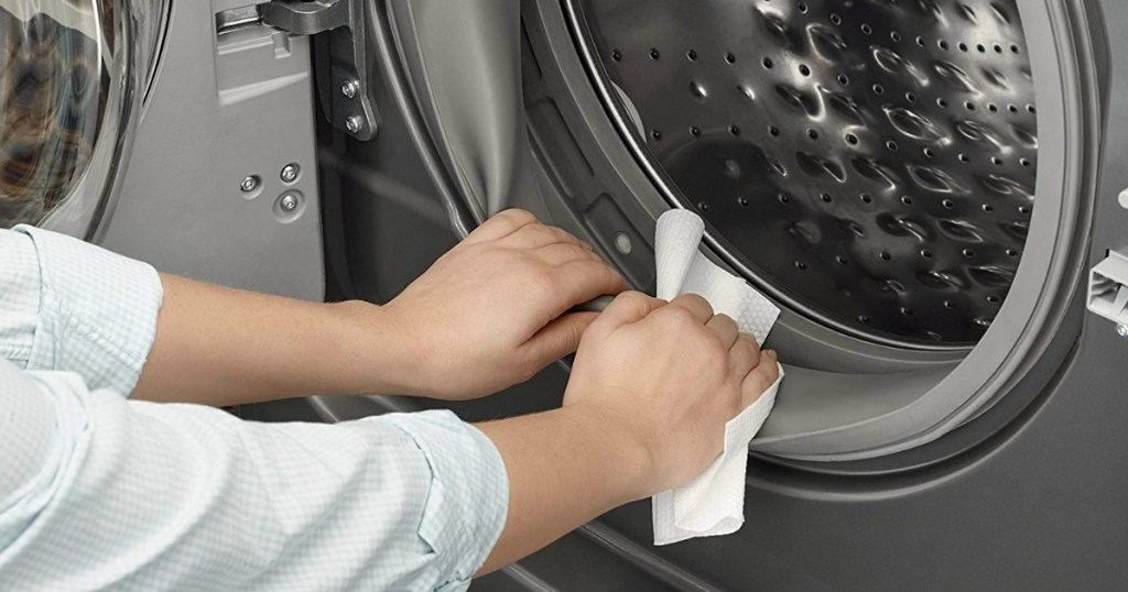 woman using affresh wipe on washing machine