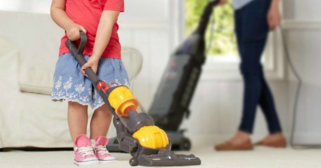 child using toy vacuum