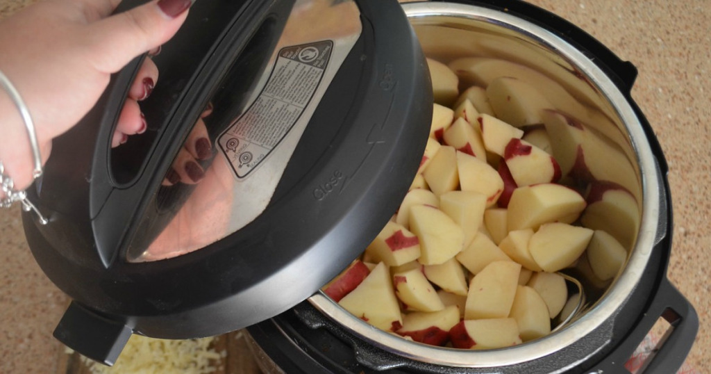 instant pot pressure cooker lid being lifted to show food