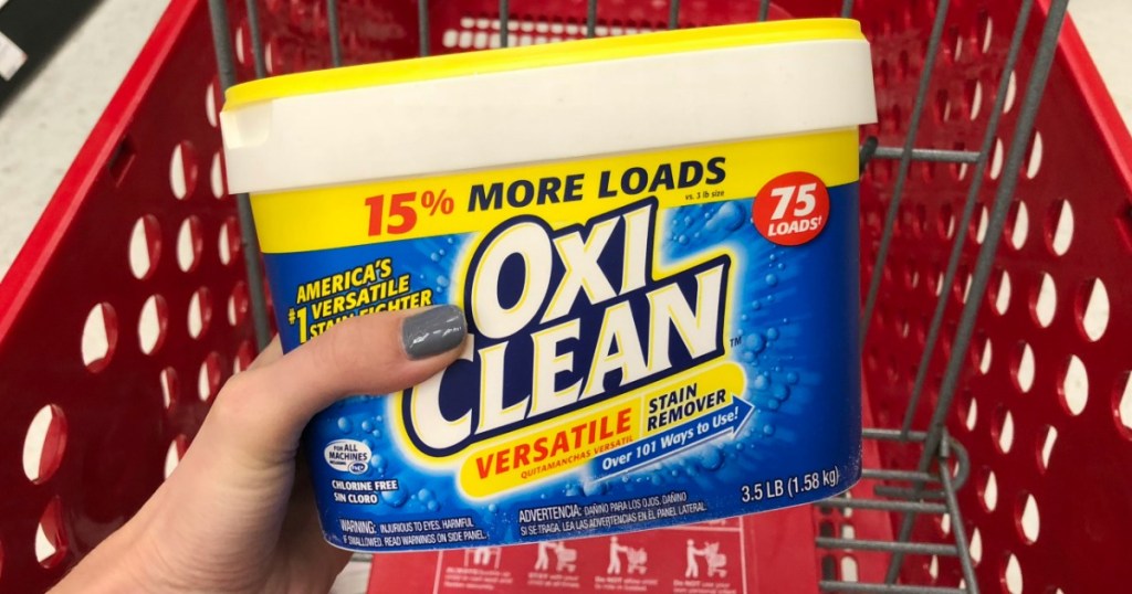 hand holding container of Oxiclean laundry detergent