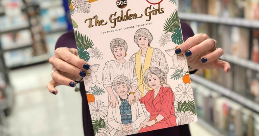 woman in store aisle holding golden girls coloring book