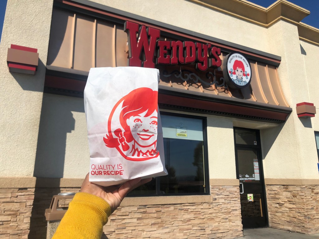 wendy's bag in hand in front of store