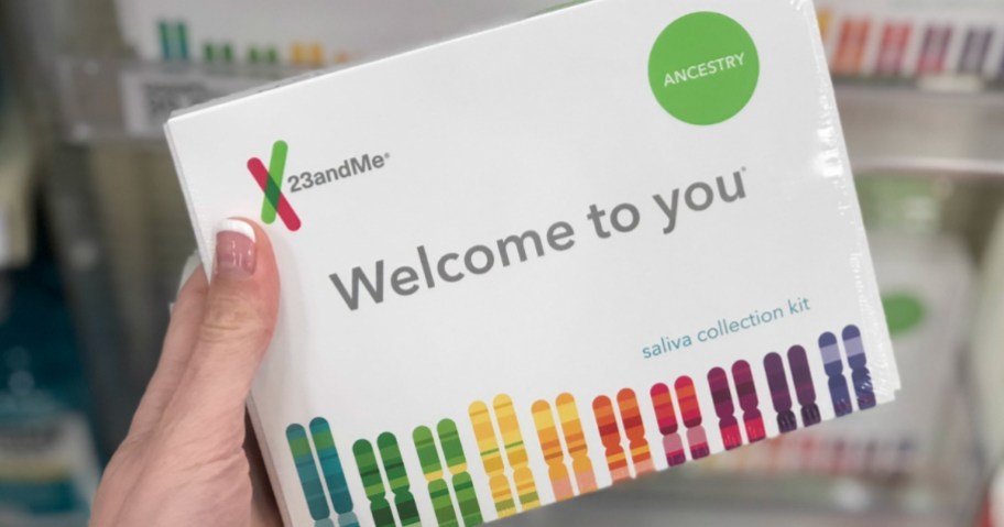 hand holding 23andme genetic kit in front of shelf