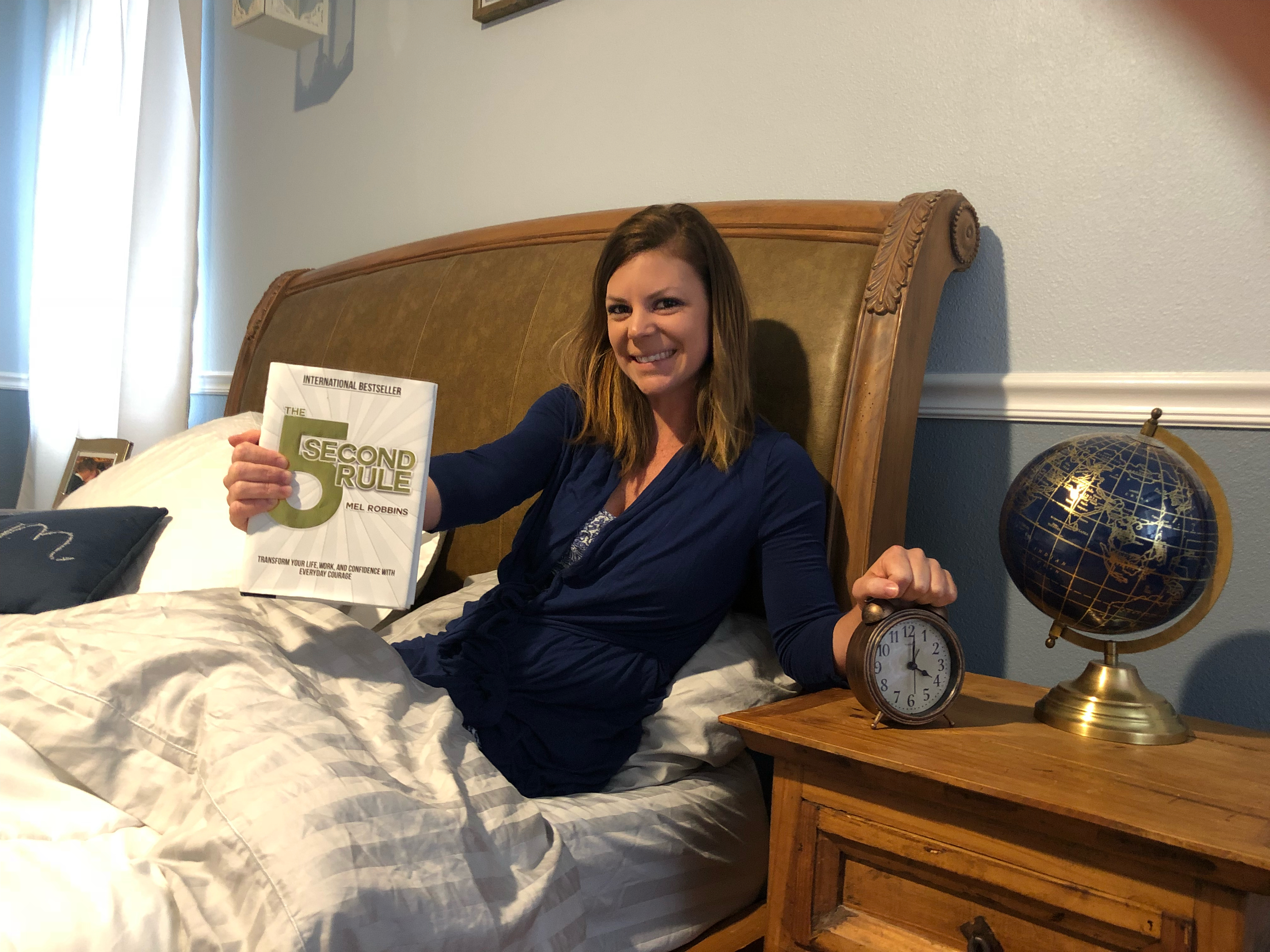 changed life 5 seconds – Erica holding the 5-second rule book and her alarm clock, smiling