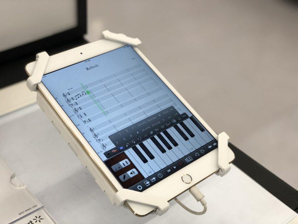 ipad mini on display in a store with a piano on the screen