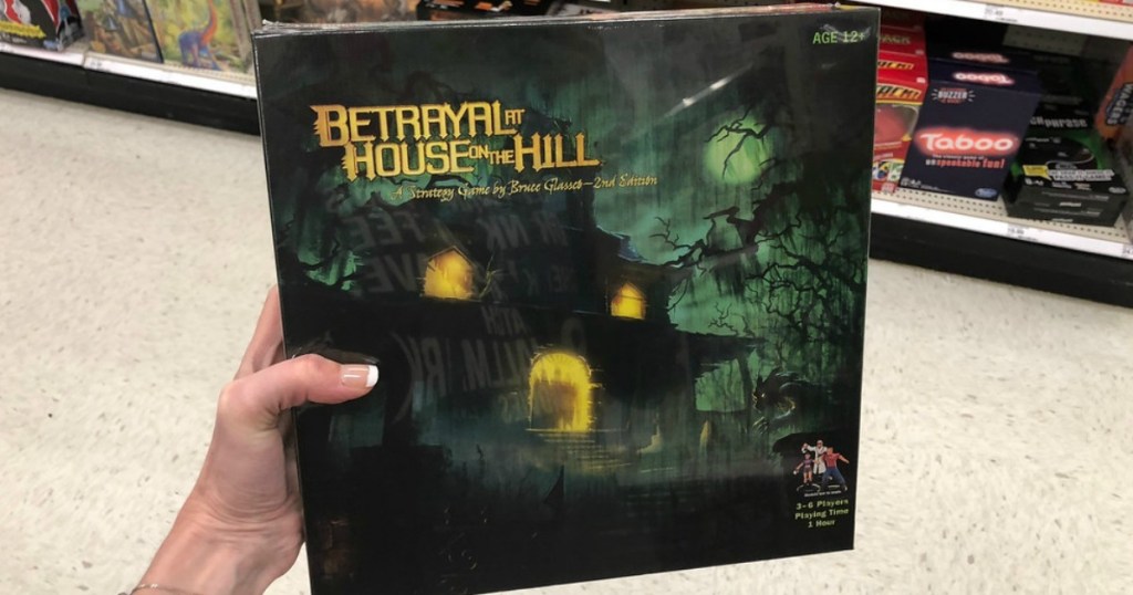 Hand holding up Betrayal At House on the Hill Strategy Board Game at store