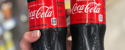 hand holding coke bottles in store