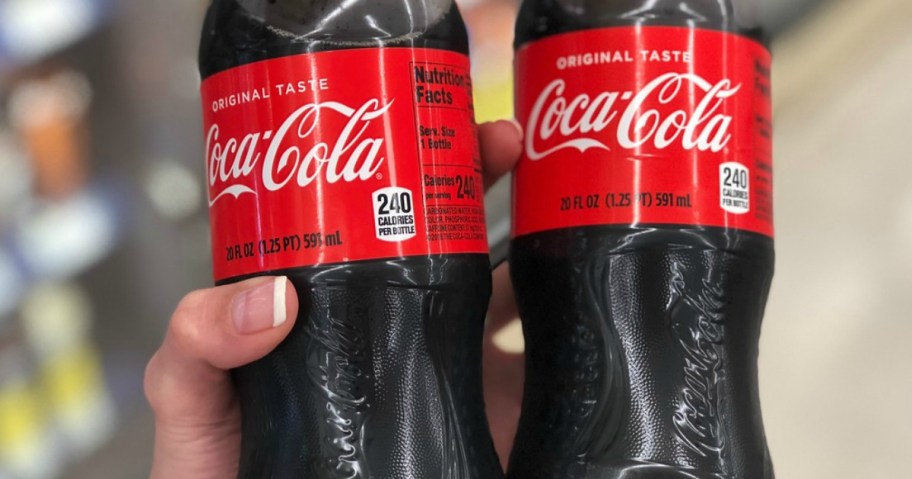 hand holding coke bottles in store