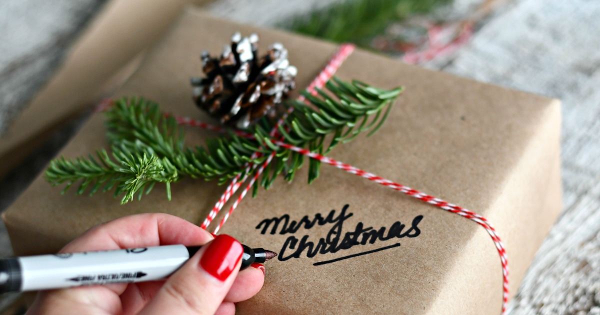writing "Merry Christmas" on gift