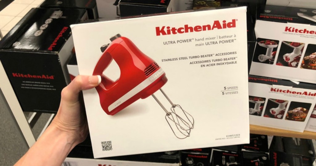 hand holding red hand mixer