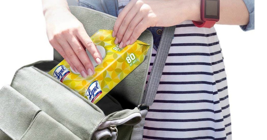 woman putting lysol handy wipes pack into purse