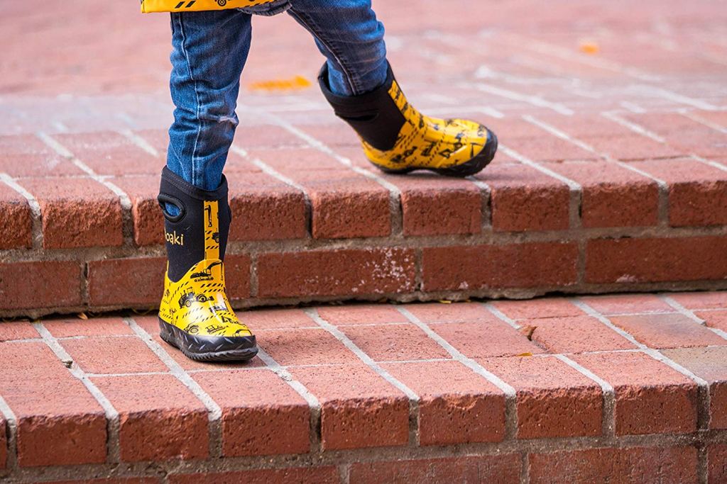 kid walking down steps in oaki yellow boots